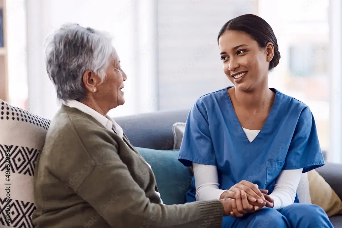 RN comforting a patient while sitting on a couch
