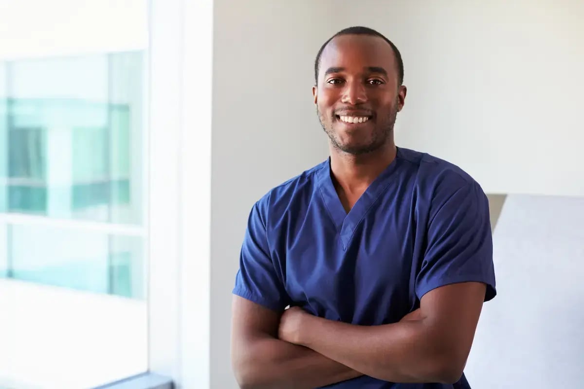 Radiation therapist smiling and crossing his arms