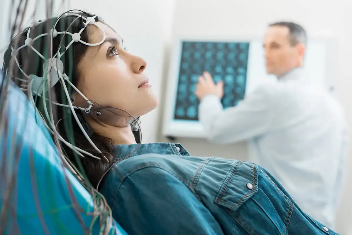 EEG tech using a EEG machine on a patient