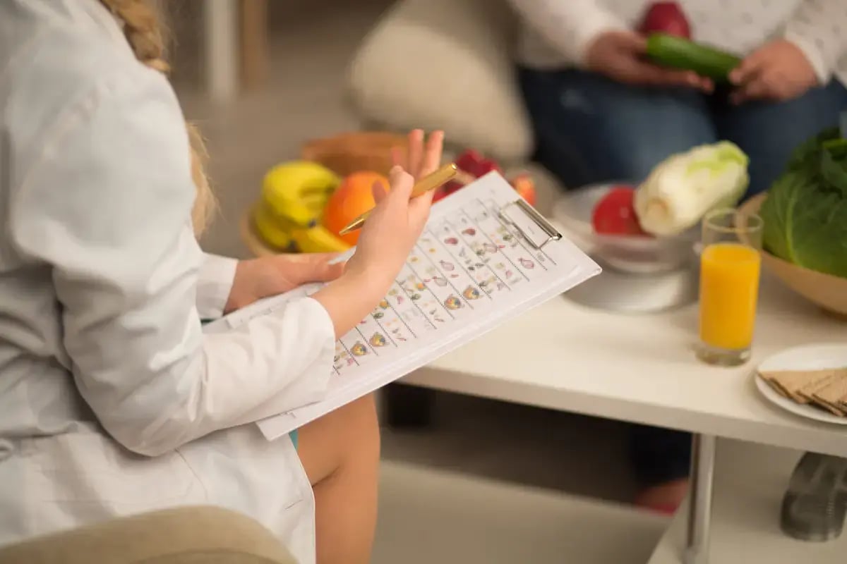 Dietician speaking to a patient with a clipboard