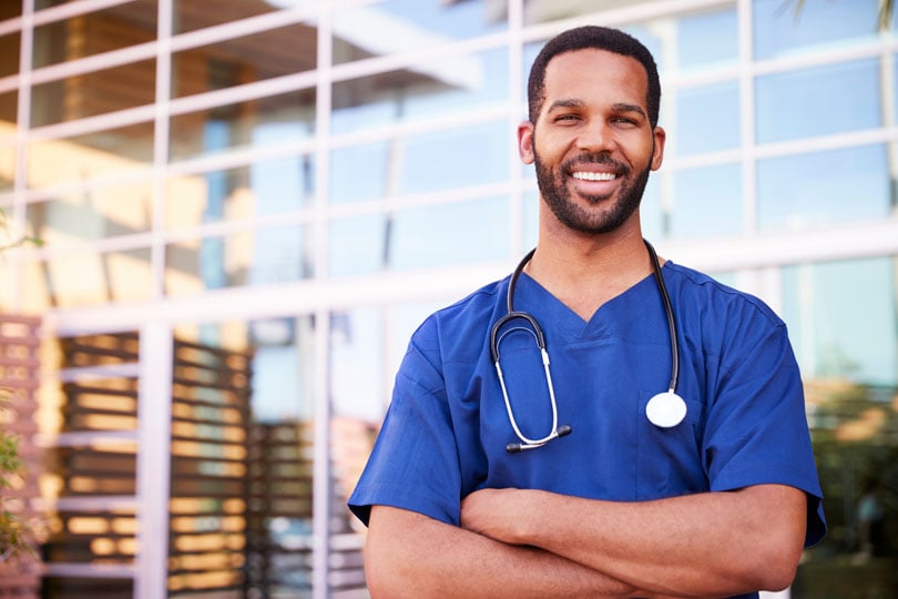 Nurse smiling while standing outside