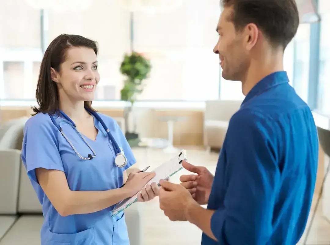 RN on a travel assignment in NC talking with a patient in a clinic lobby