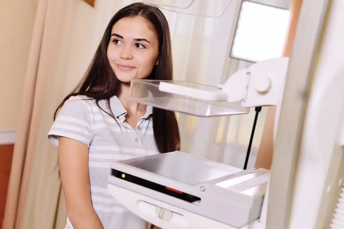 Mammographer standing next to x-ray machine