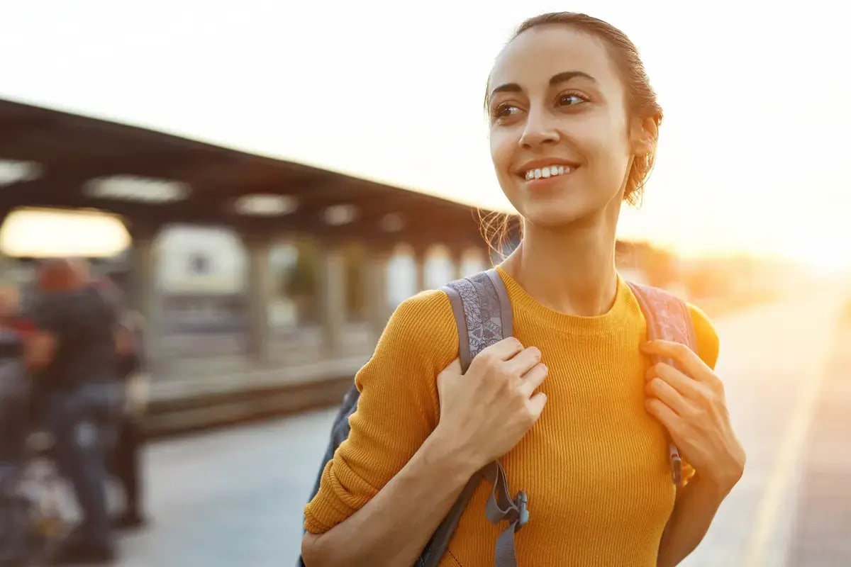 Travel dietician at a train station with a backpack on