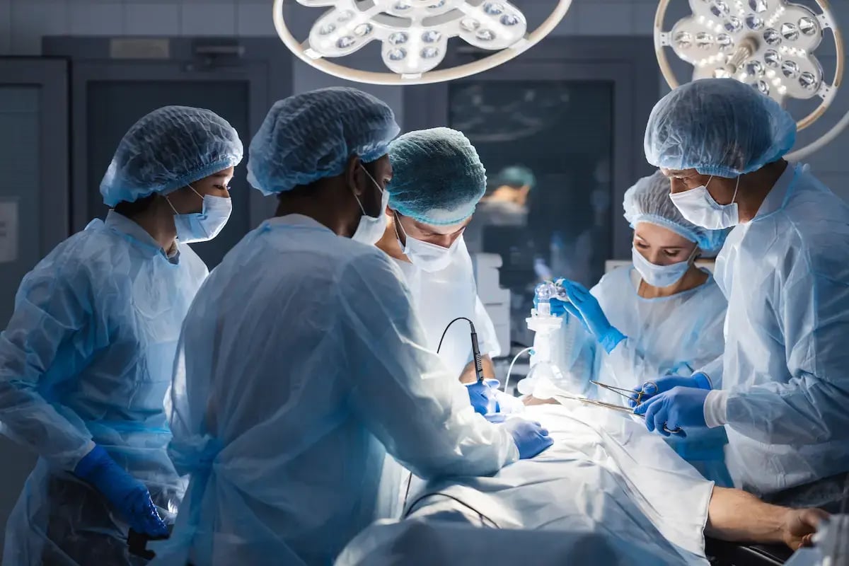 Operating room technicians assist a surgeon during surgery