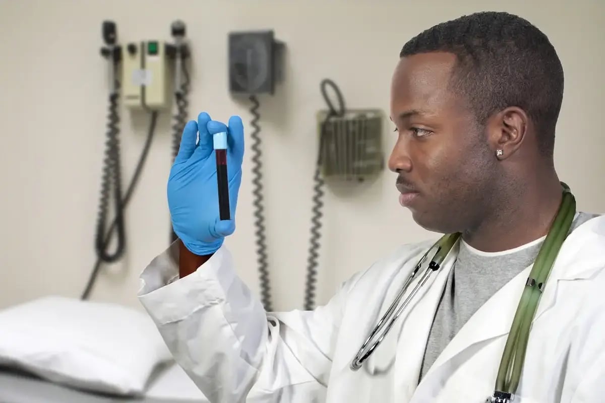 Phlebotomist looking at a vial of blood