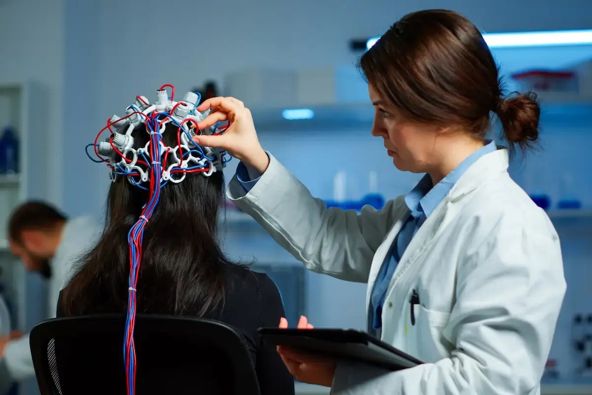 EEG tech fitting a patient with EEG electrodes
