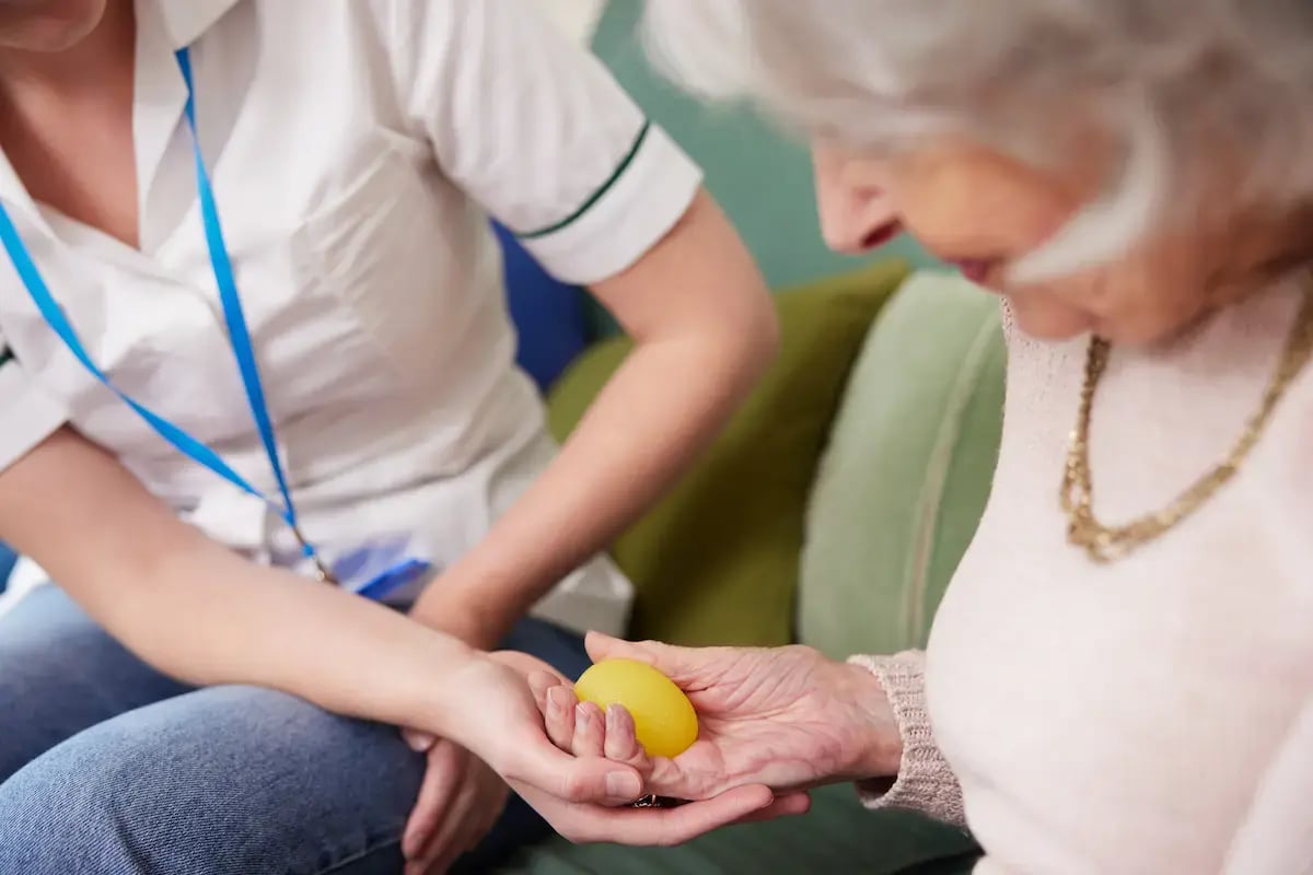 Occupational therapist helping an elderly patient with their motor skills