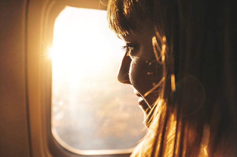 Woman looking out the window of a plane
