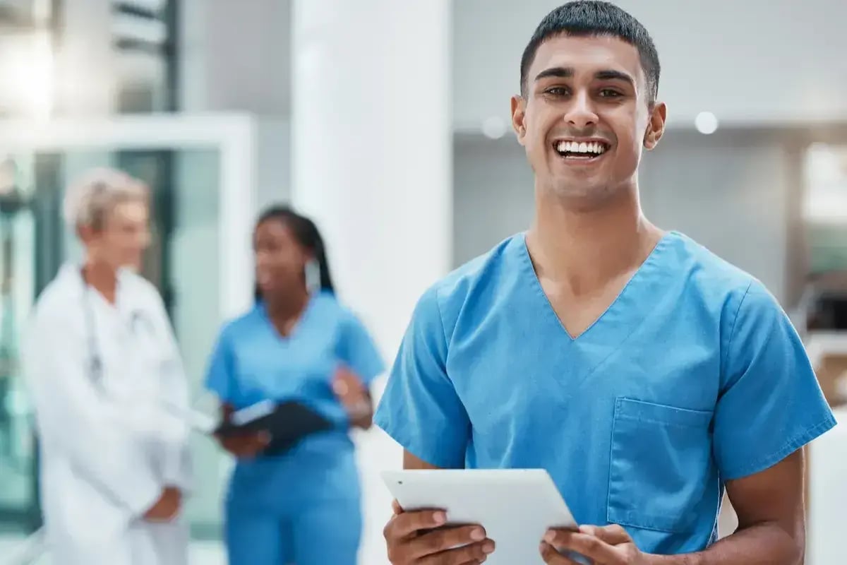 Medical assistant smiling and holding a tablet