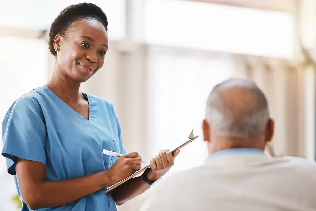 RN interviewing an elderly patient while at work