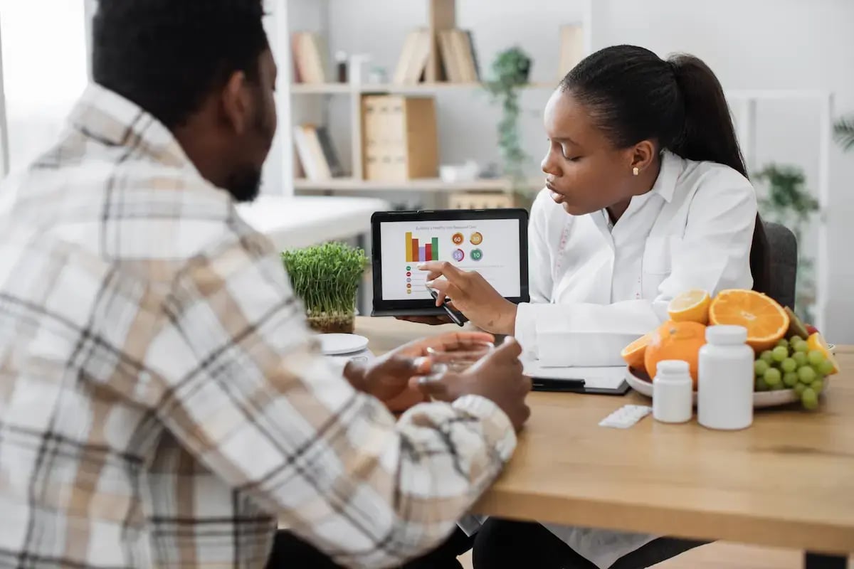 Dietician showing a patient a slideshow on a tablet