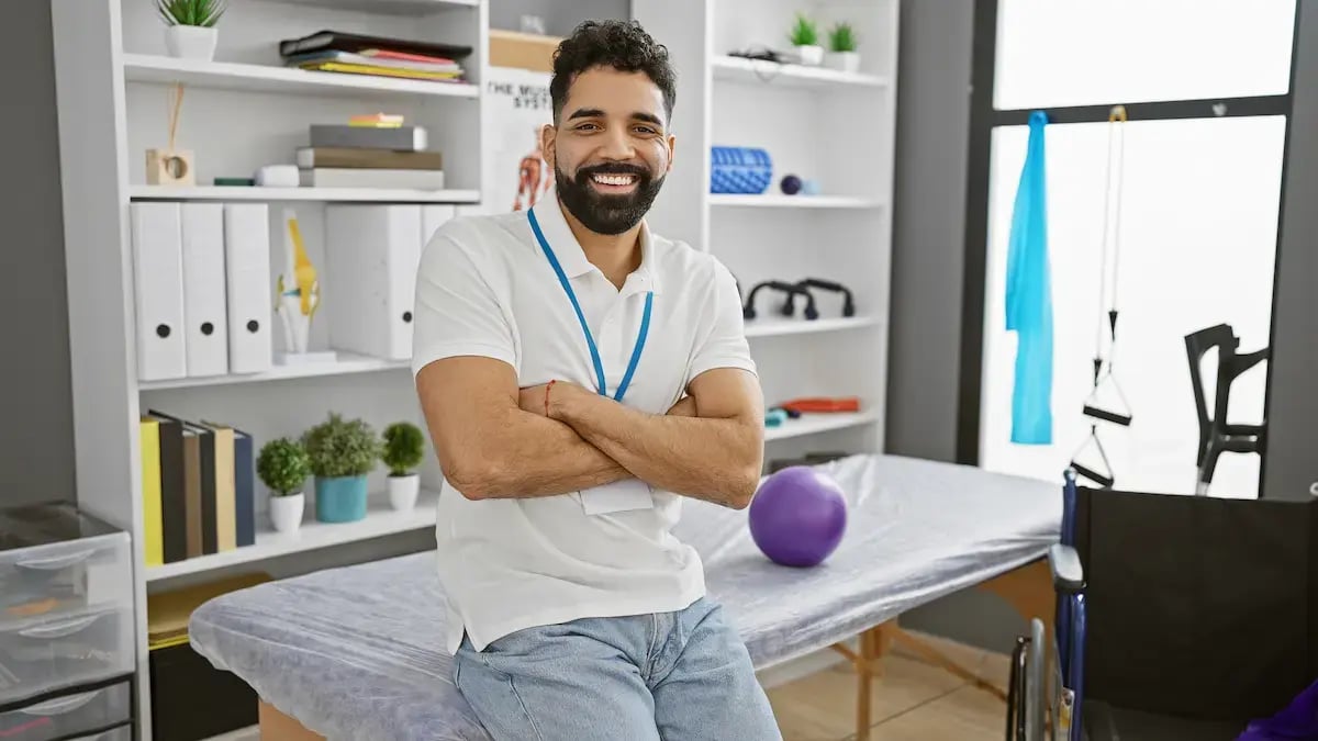 Occupational therapist smiling and crossing his hands in his office