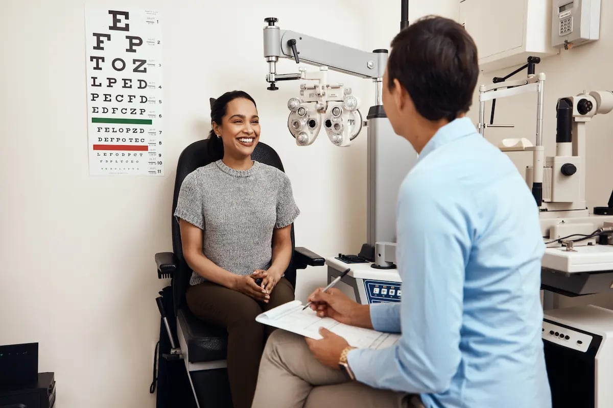 Woman getting an eye exam from an optometrist while in the exam room