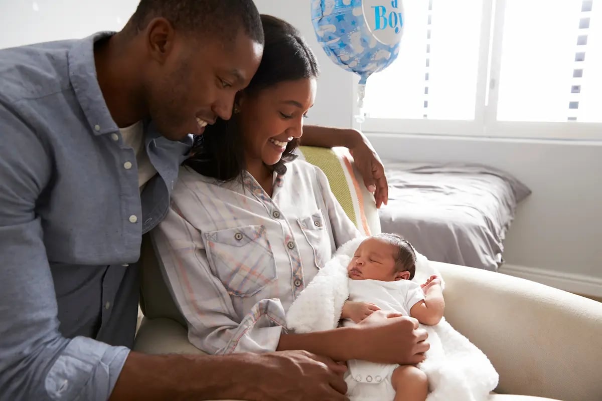 Family in the hospital holding their newborn and enjoying paid parental leave