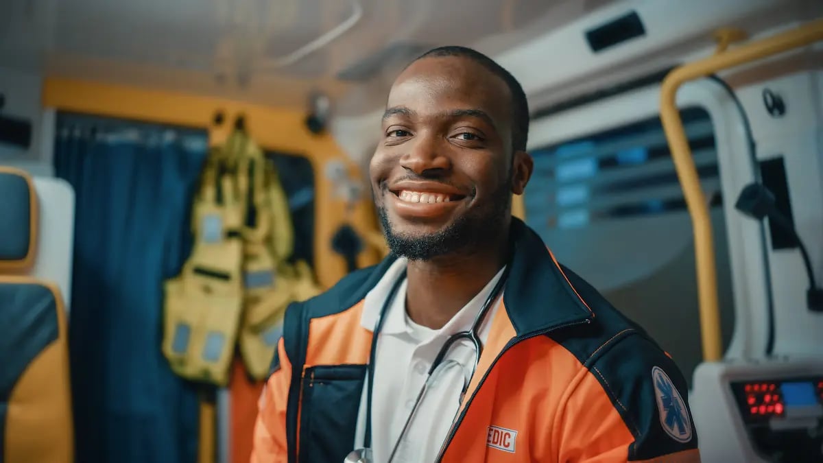 Emergency response paramedic smiling and sitting in an ambulance