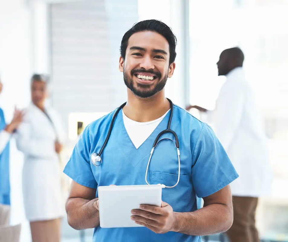 RN with a full-time job smiling and holding a tablet with physicians in the background