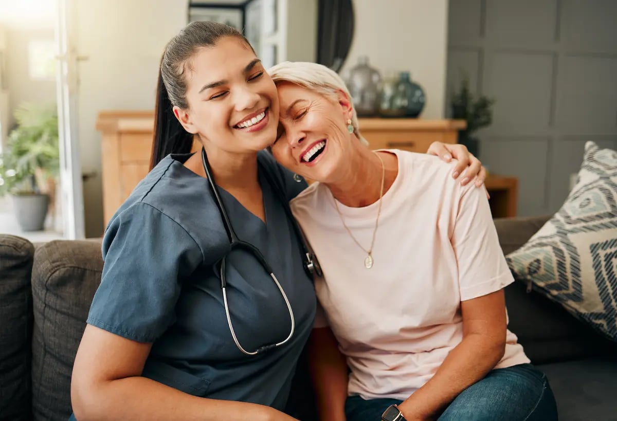 A long-term care nurse giving an elderly patient a hug