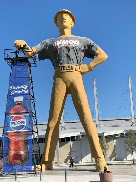 Travel nurse stands below giant Golden Driller statue in Tulsa, Oklahoma
