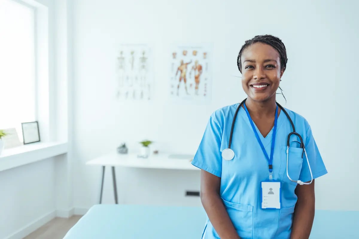 A physical therapist standing and smiling in a rehab center