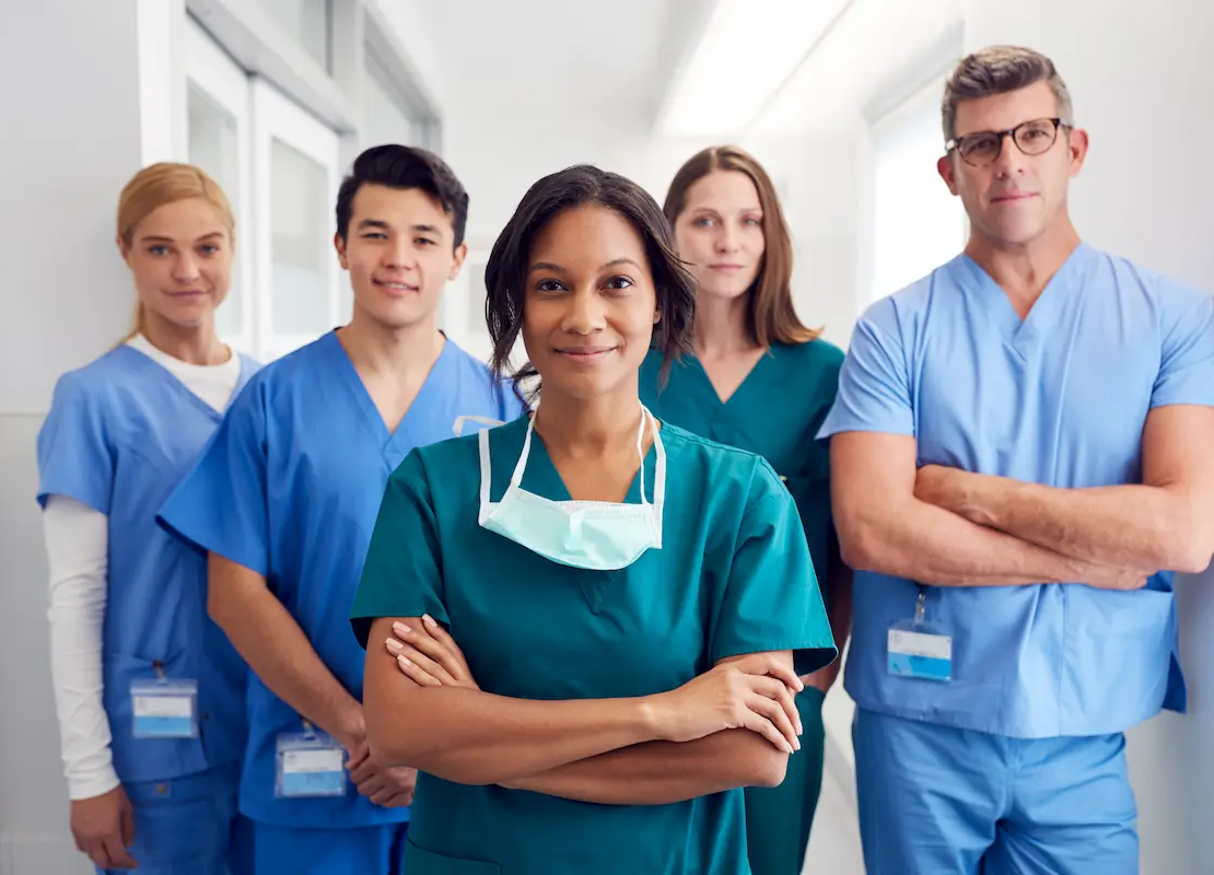 Group of nurses and allied health professionals standing in a hospital hallway