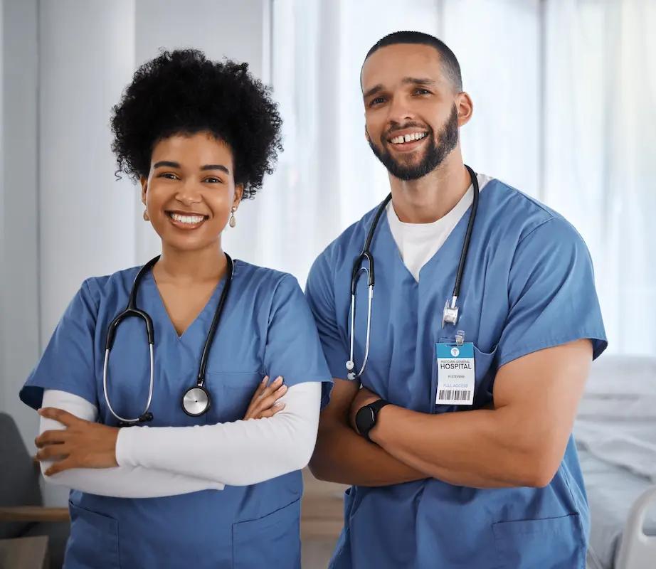 Two nurses standing and smiling with their arms crossed