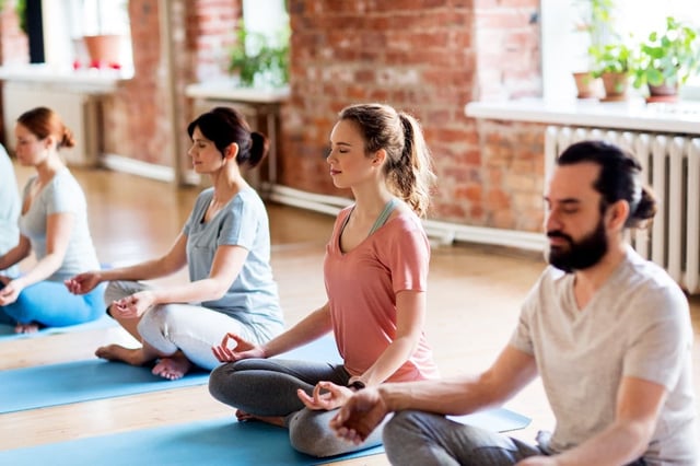 Group of people meditating in a yoga class
