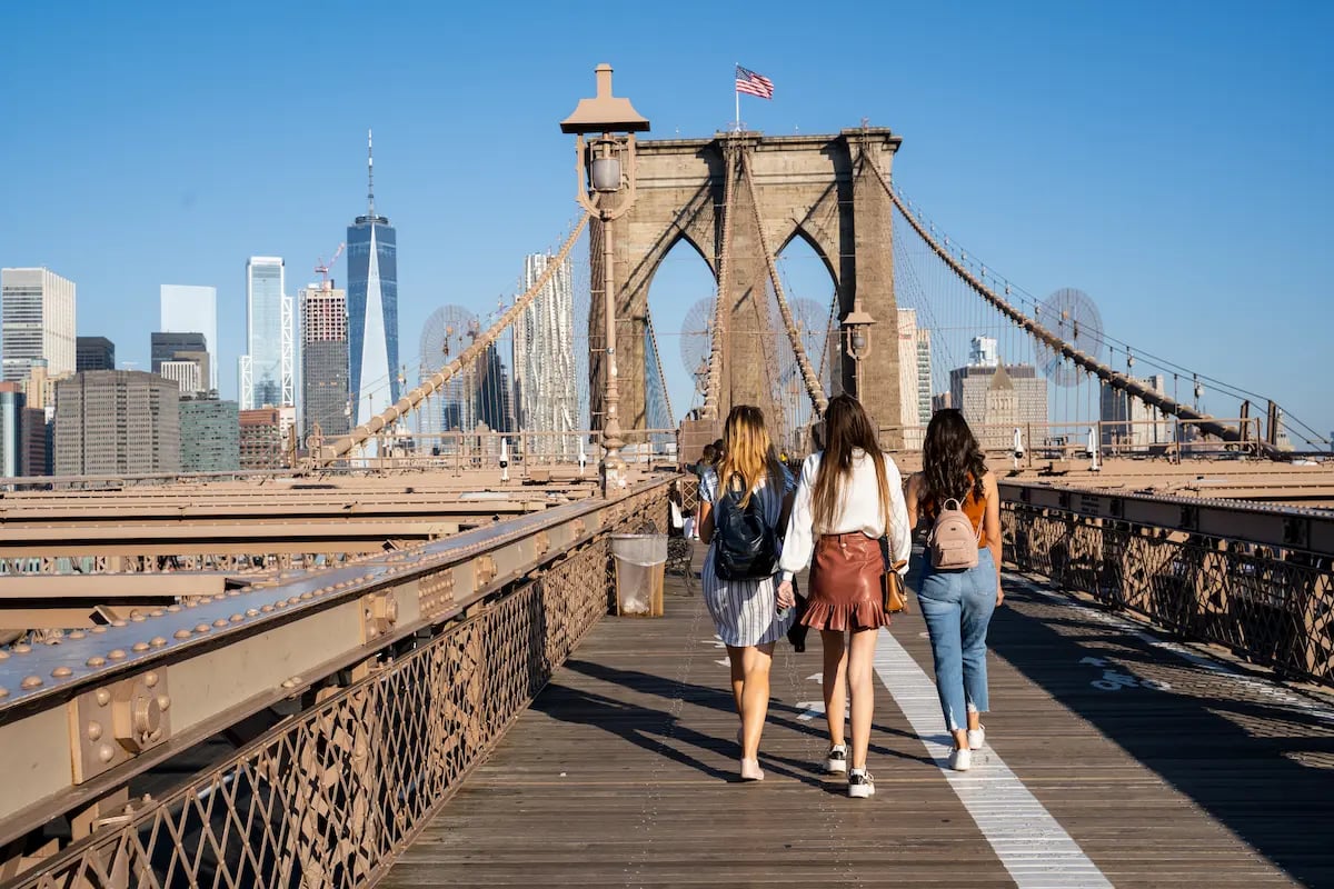 Three off duty travel nurses walking on the Brooklyn Bridge in New York City while on assignment