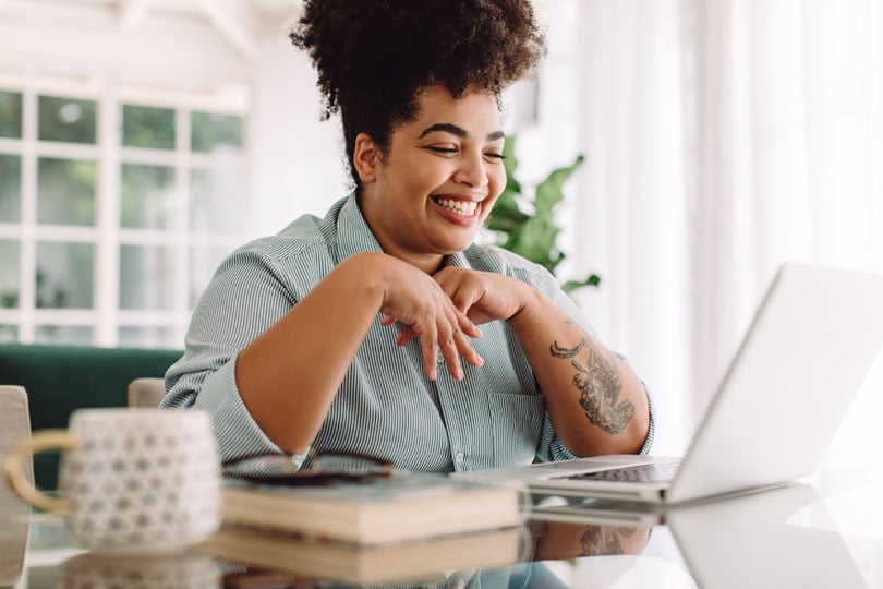 Non-clinical worker smiling at a laptop