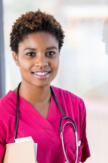 School nurse in scrubs smiling at the camera