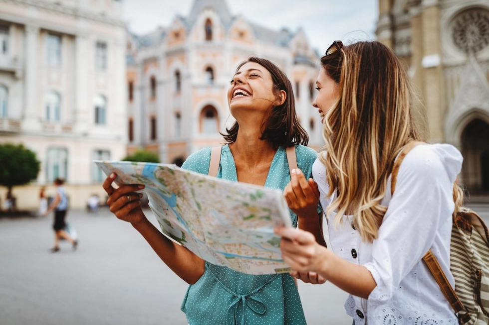 Two first-time travel nurses nurses looking at a map while sightseeing