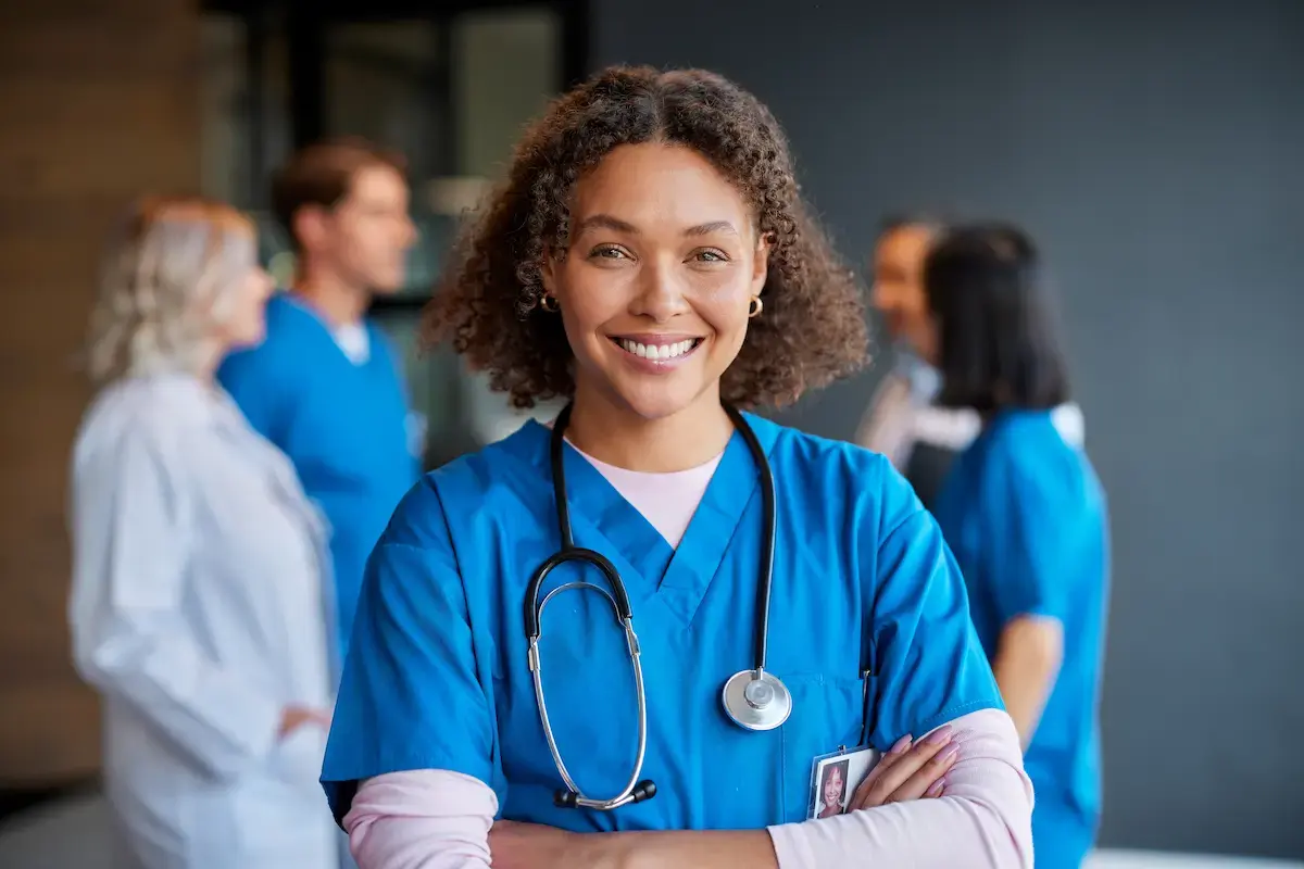 CNA smiling and crossing her arms in a hospital