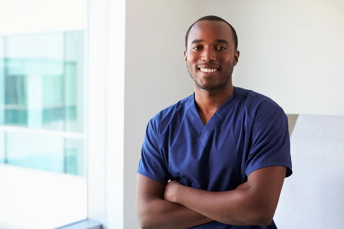 Radiation therapist smiling and crossing his arms