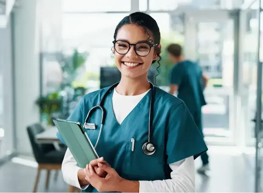 Travel registered nurse smiling with a tablet while on assignment in Alaska