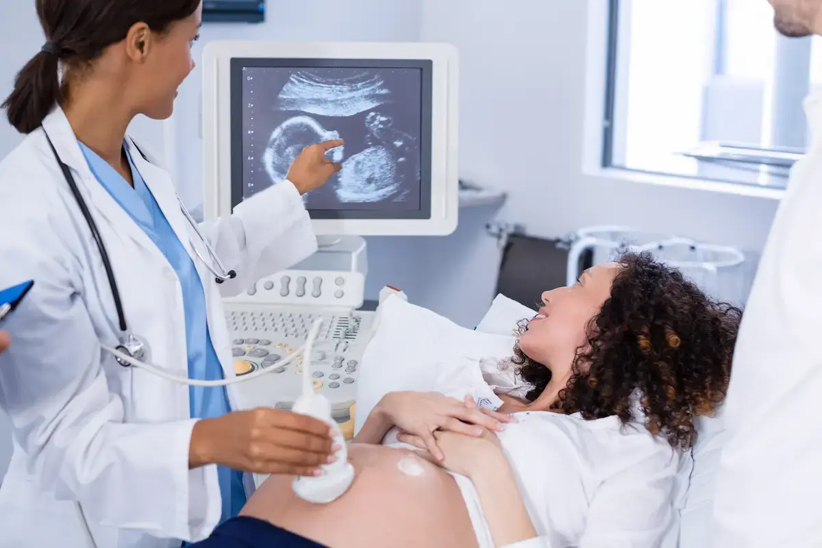 Ultrasound technician examining a pregnant woman with an ultrasound machine