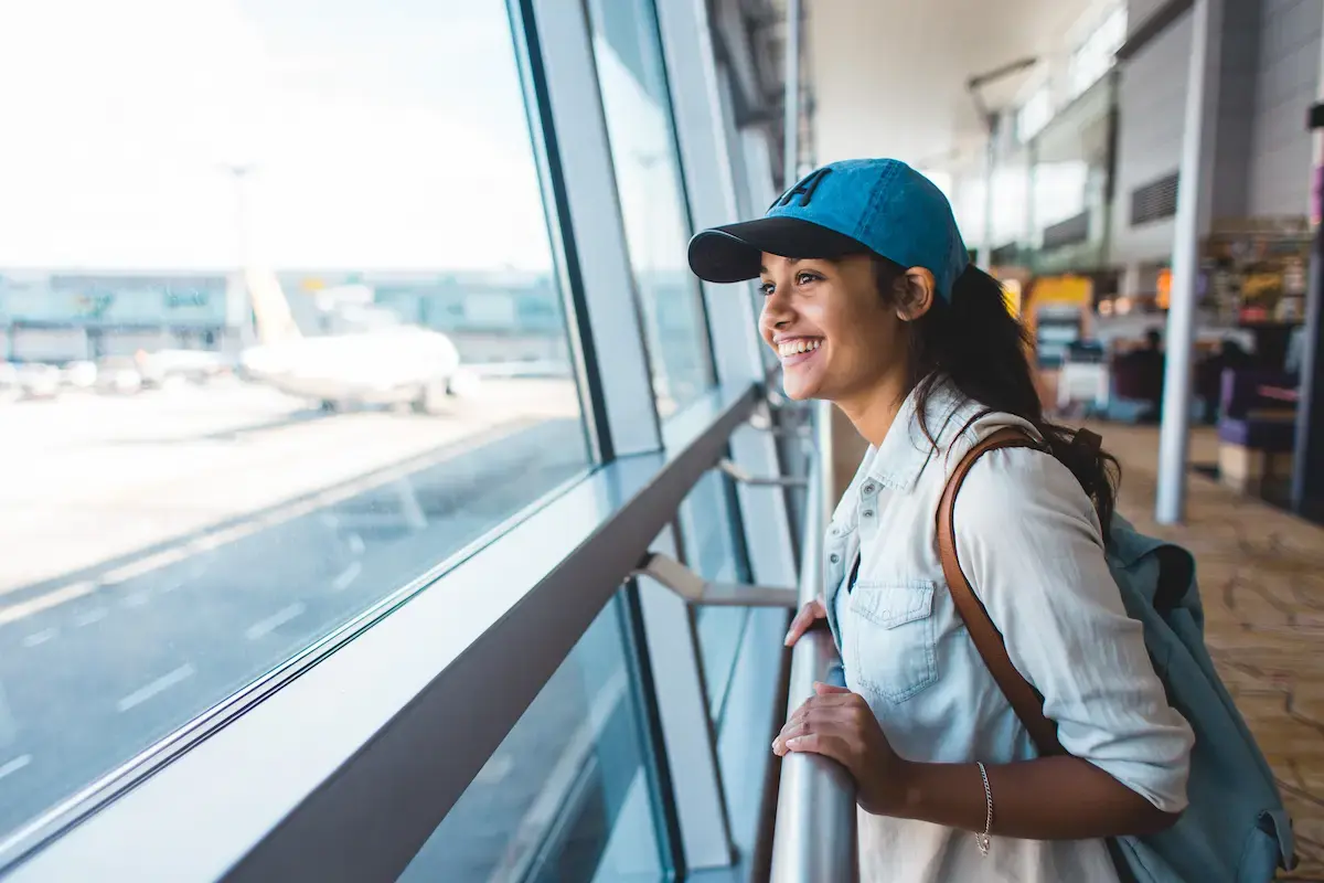 Travel MRI tech looking out the window of an airport, heading to her next travel assignment