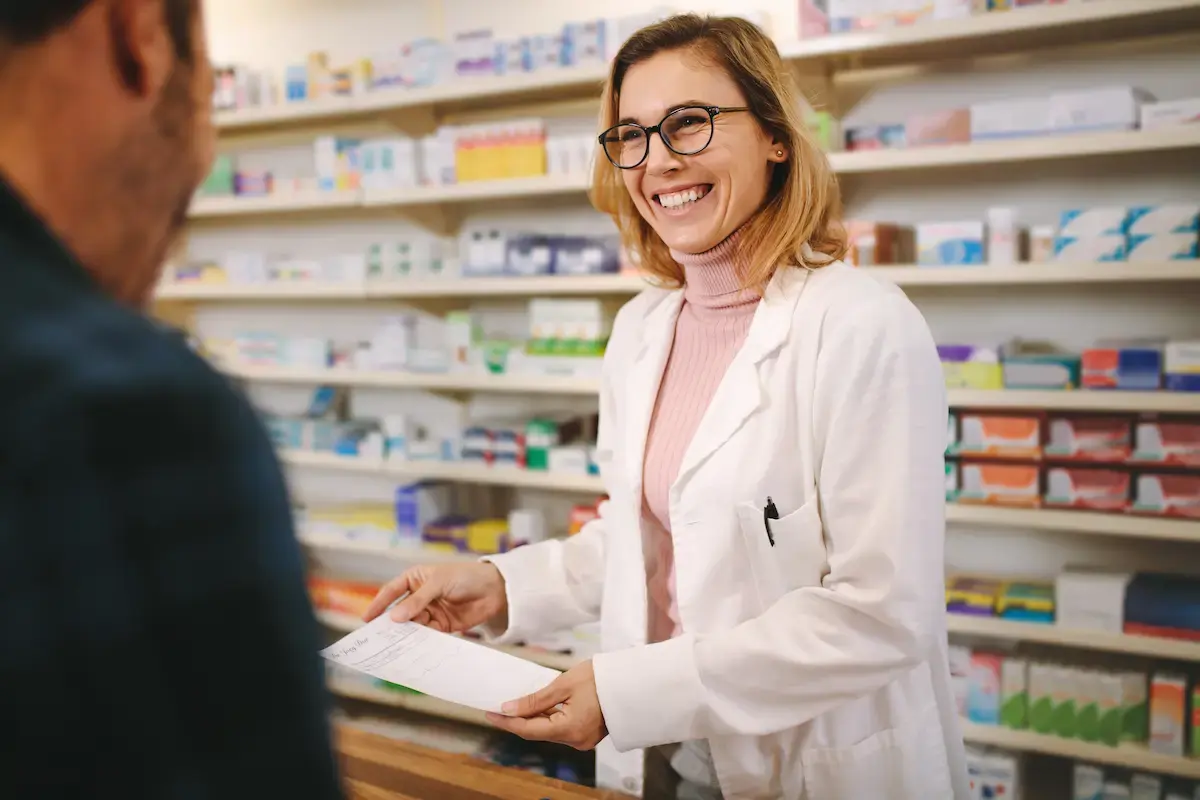 Pharmacist smiling and fulfilling prescriptions