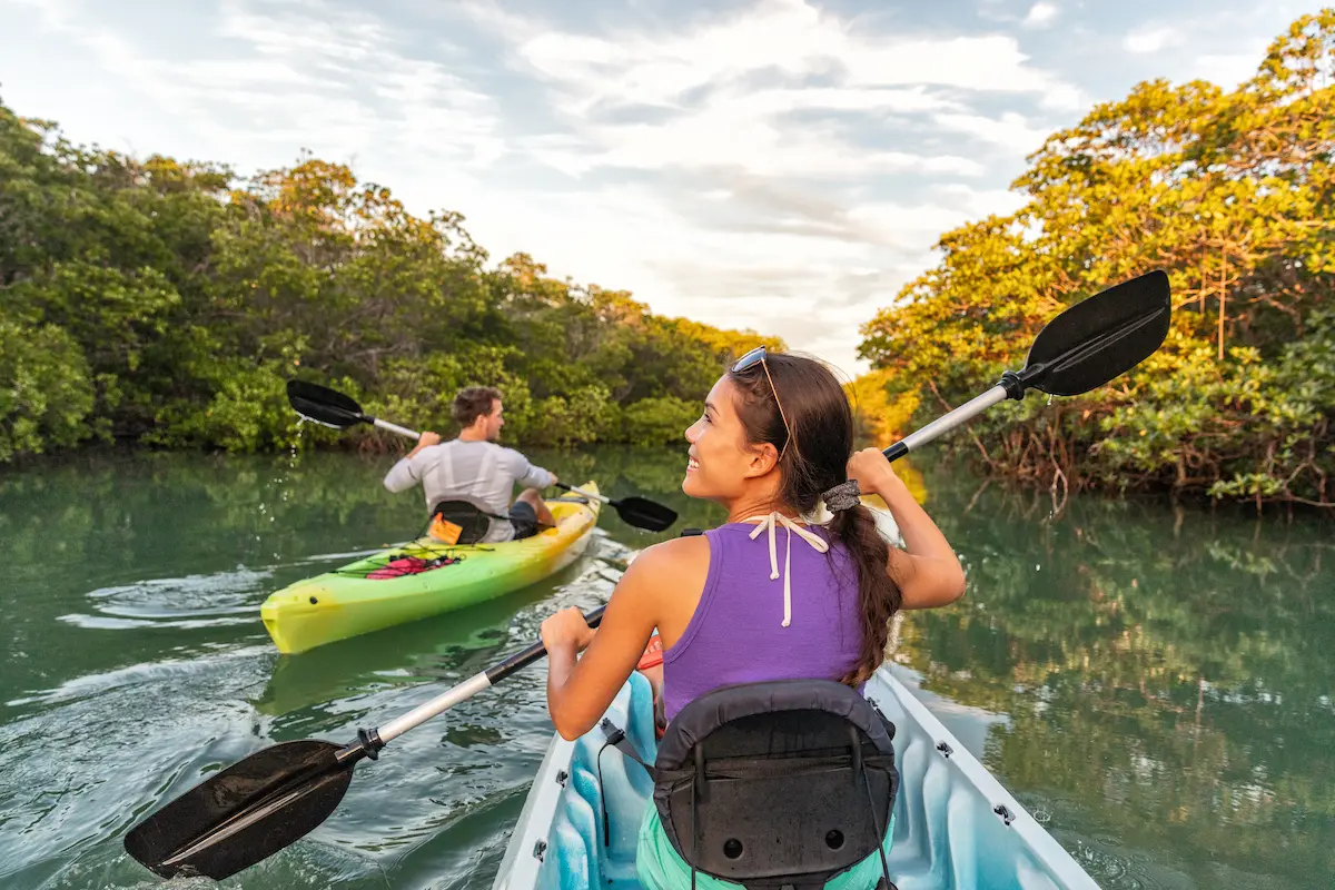 Two nurses kayaking down a river while on their first travel nursing assignment