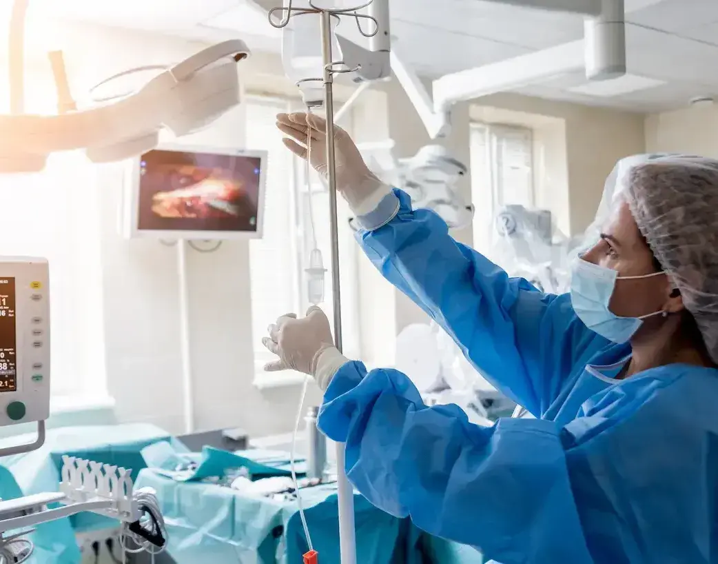 ICU RN using a medical drip on a patient in the ICU