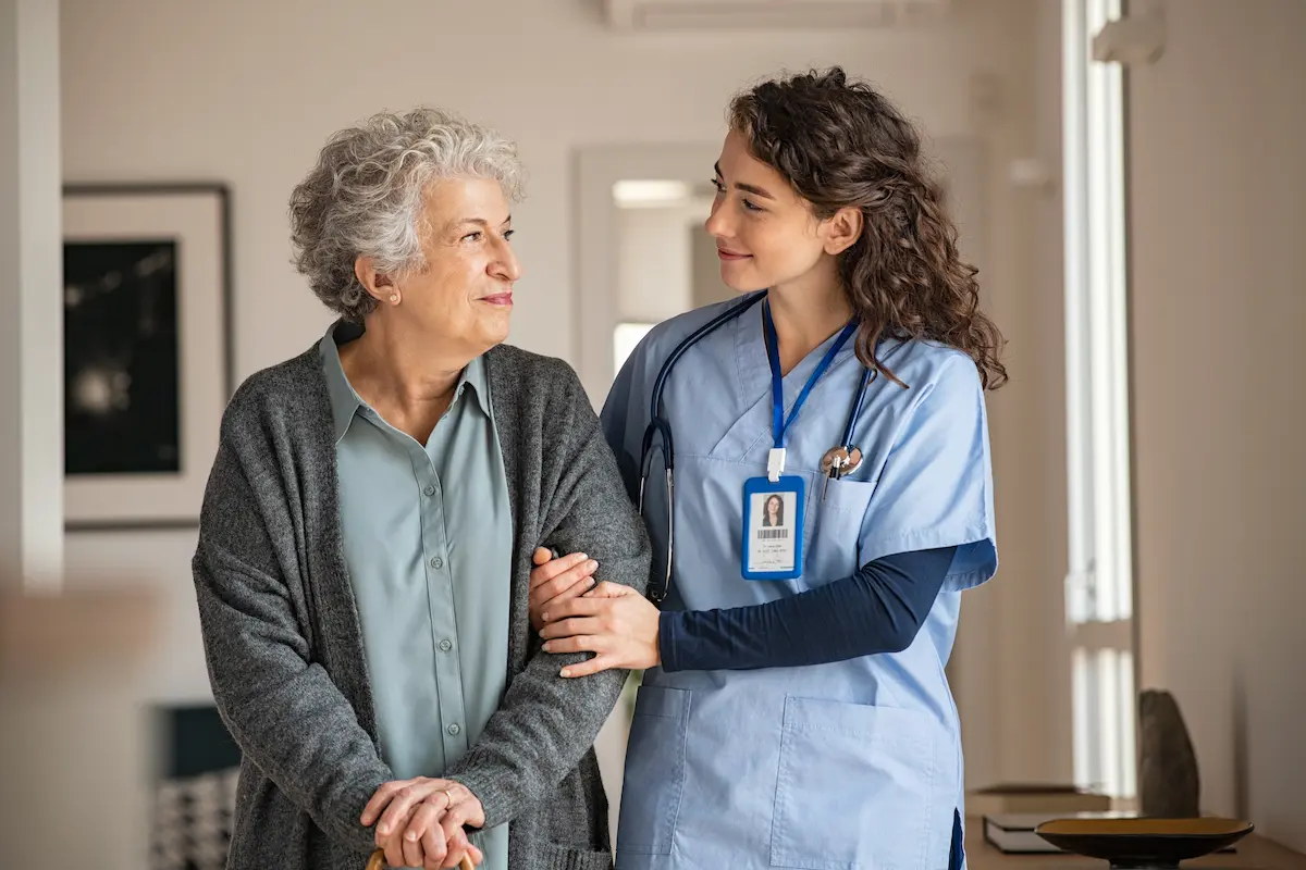 Nurse holding the arm of an older patient in a nursing home