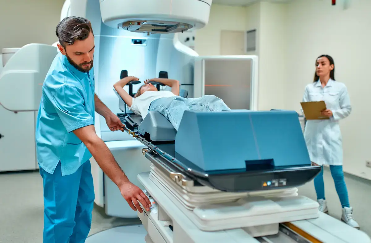 Patient undergoing radiation therapy for cancer under the supervision of a radiation therapist in a hospital