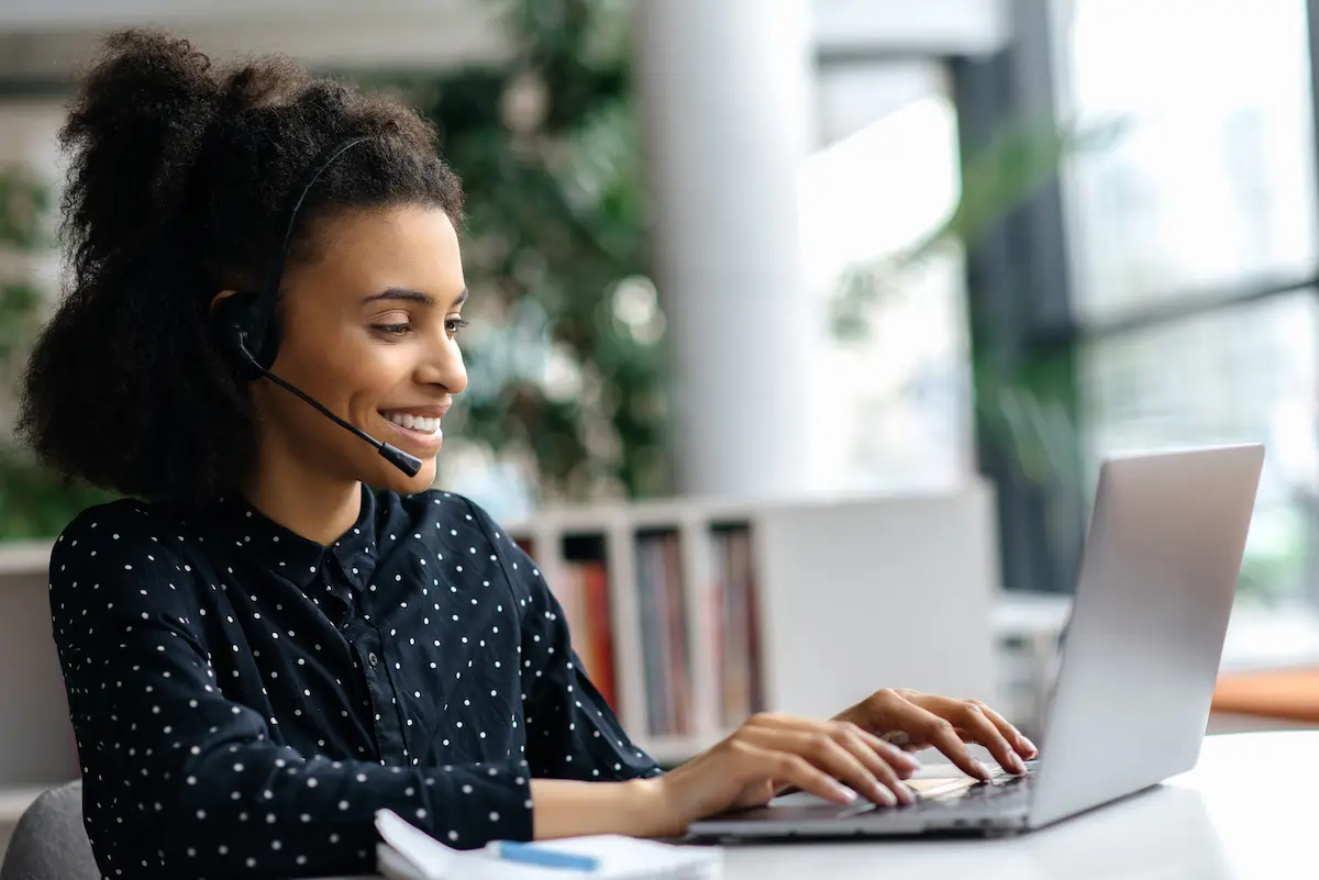 A healthcare recruiter wearing a headset and working on their laptop in an office