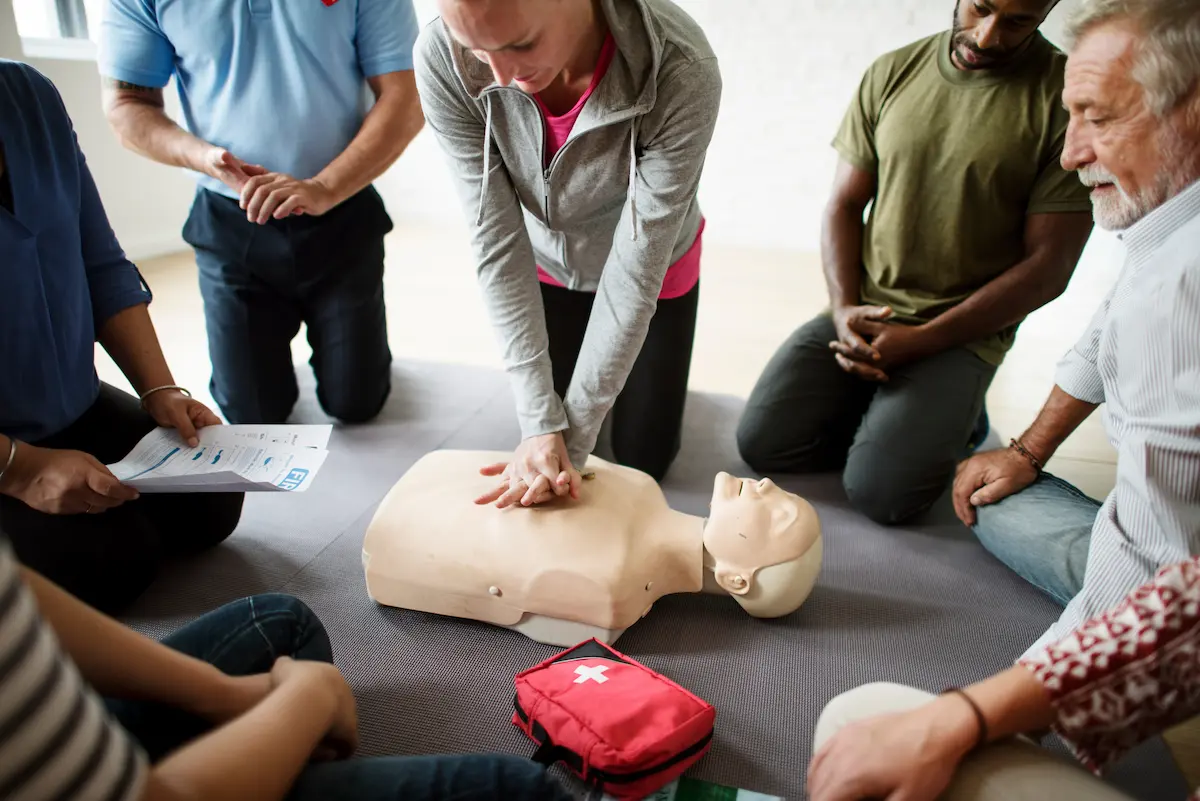 Group of nurses in a BLS nursing certification class giving a dummy CPR