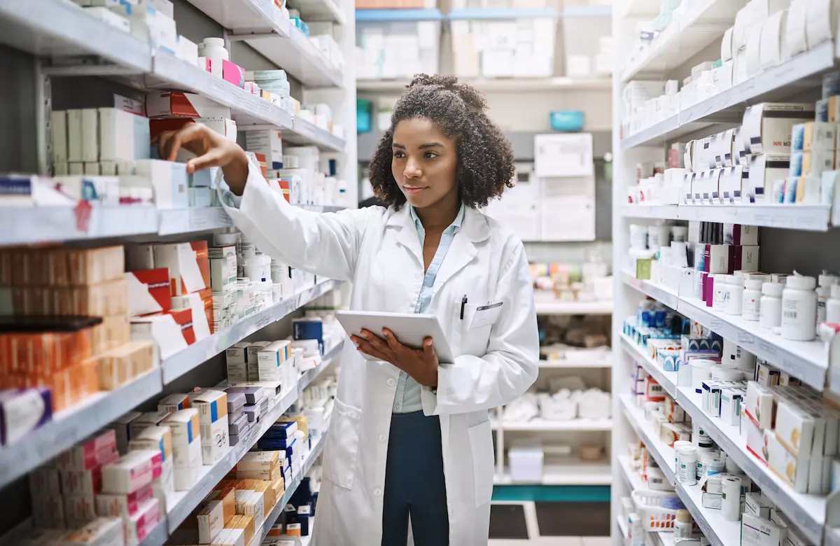 Pharmacy tech taking inventory of prescriptions in the backroom of a pharmacy