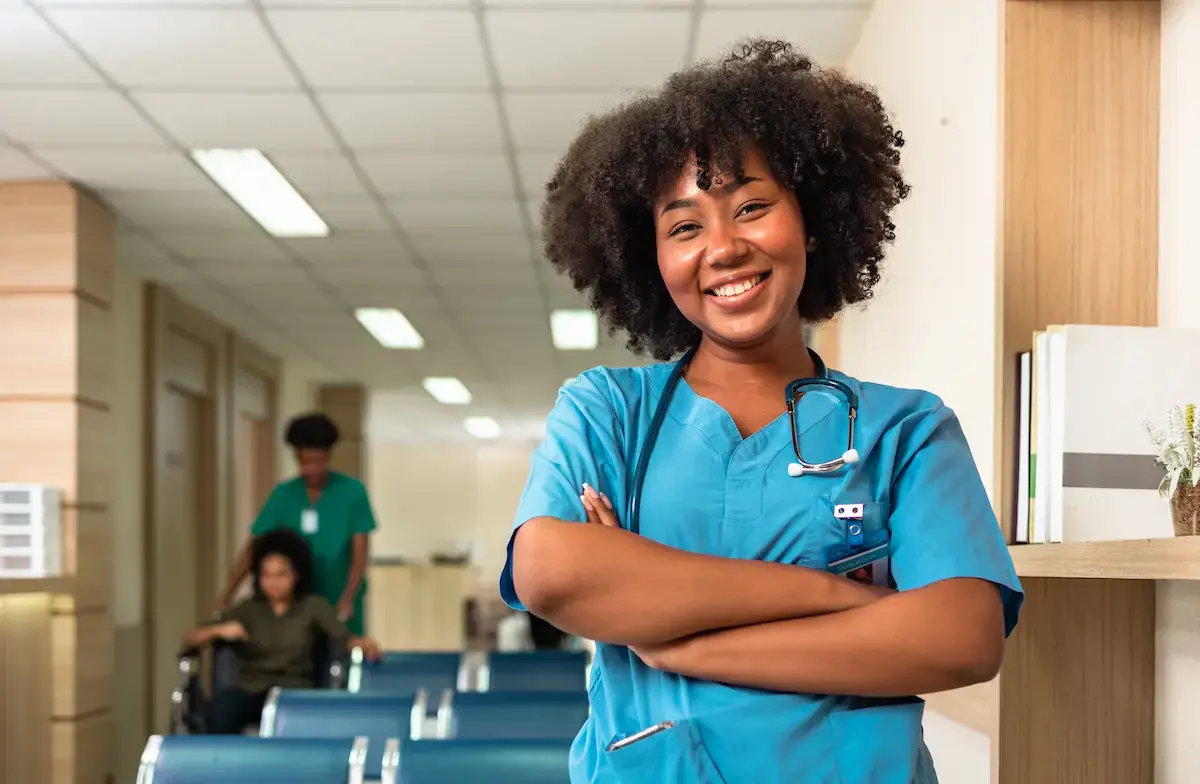 RN working in IL smiling and crossing her arms in a hospital