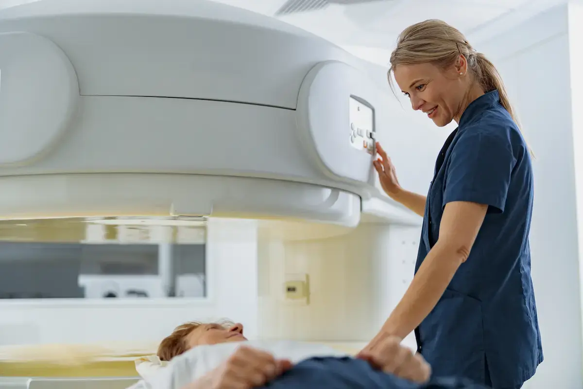 Interventional radiology tech using an open MRI machine to scan a patient