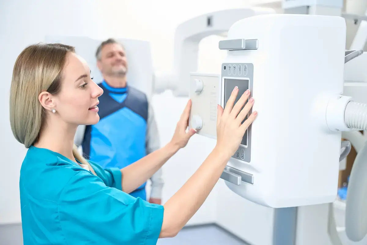 Radiologic technologist using imaging equipment on a patient