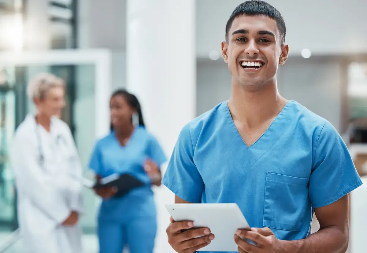 Medical assistant smiling and holding a tablet