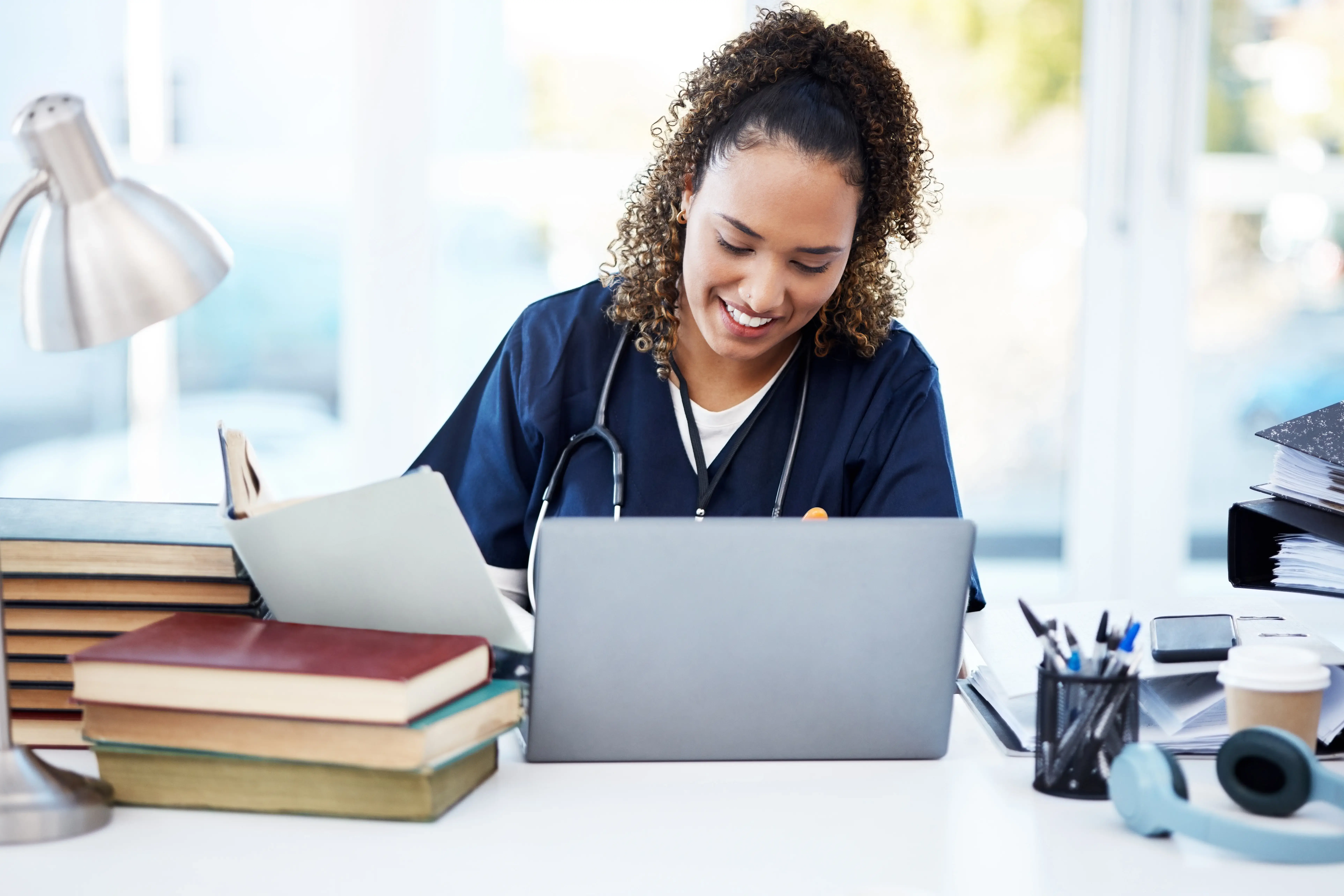 Nurse studying at a desk with a laptop