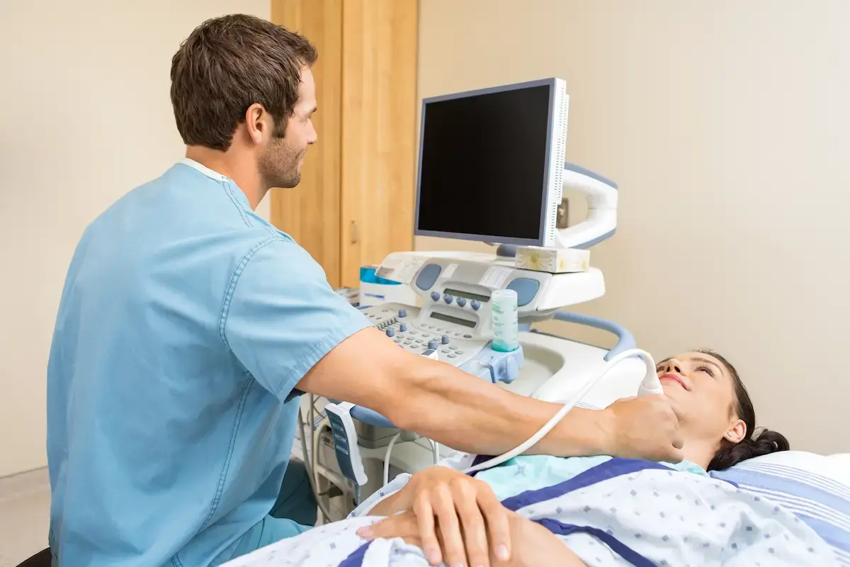 Ultrasound technician examining a patient's throat